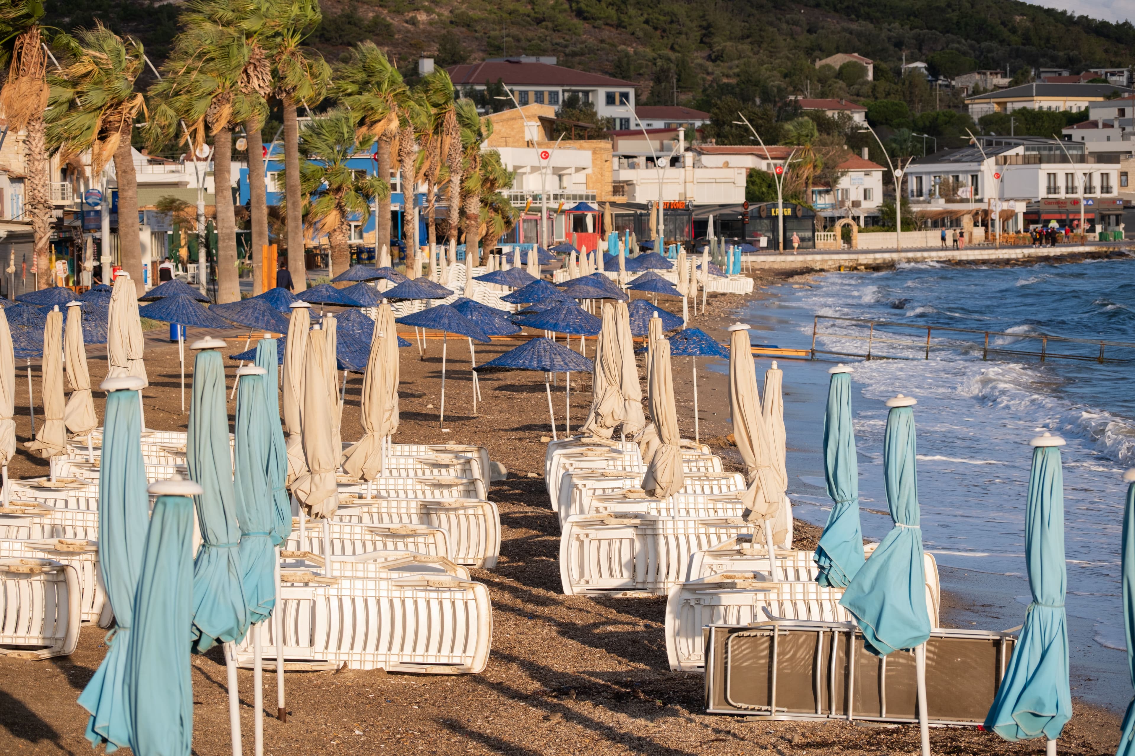 Tranquil beach scene with umbrellas lining the shore in Foça, İzmir, Türkiye.